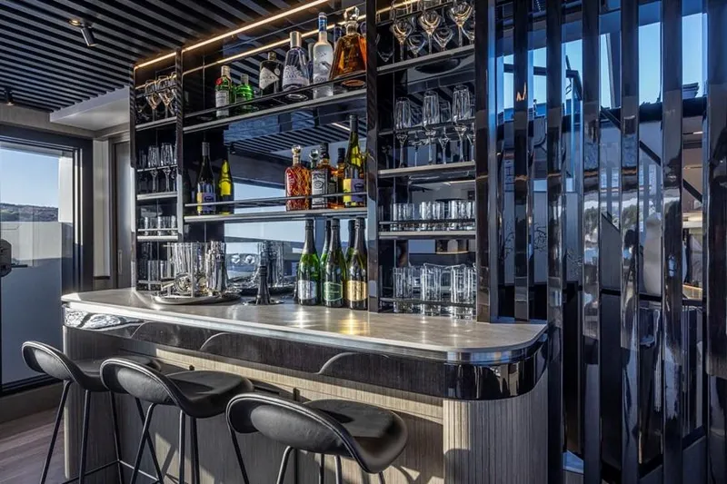 Pearly Spencer Yacht Photos Pics Luxurious bar area on the 2024 Pearl 82 yacht, featuring elegant seating and glassware.