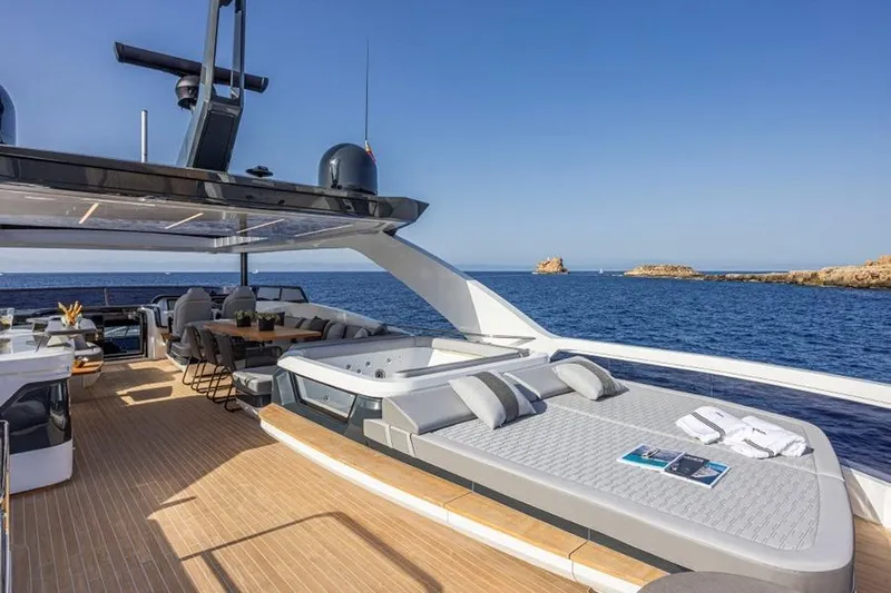 Pearly Spencer Yacht Photos Pics Luxurious 2024 Pearl 82 yacht deck with jacuzzi, sunbeds, and ocean view.