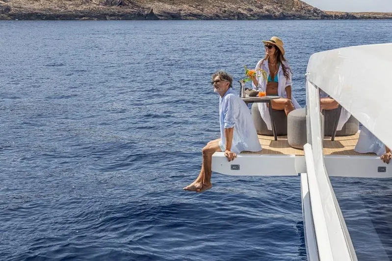 Pearly Spencer Yacht Photos Pics People relaxing on a 2024 Pearl 82 yacht, enjoying the ocean view.