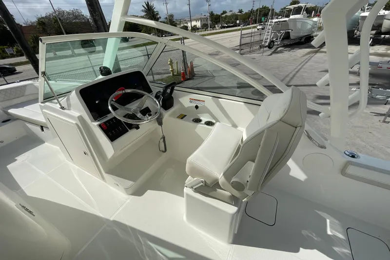 55889 230dc Sf Yacht Photos Pics 2025 World Cat 230 DC boat cockpit with steering wheel and captain's chair.