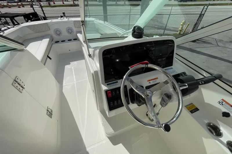 55889 230dc Sf Yacht Photos Pics Interior view of 2025 World Cat 230 DC boat cockpit with steering wheel and controls.