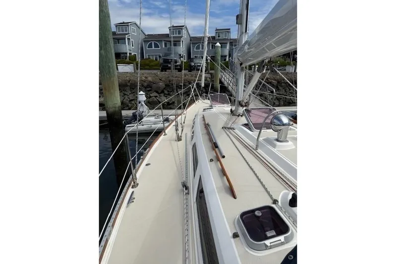 Star Yacht Photos Pics 1998 Sabre 402 sailboat docked near waterfront homes, showcasing deck and rigging.