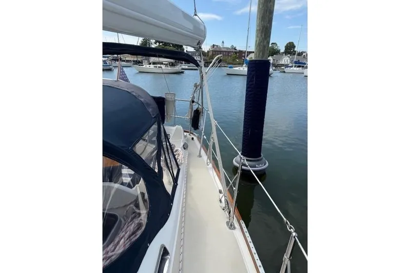 Star Yacht Photos Pics Sailboat docked at marina, Sabre 402, 1998 model, with blue canopy and calm waters.