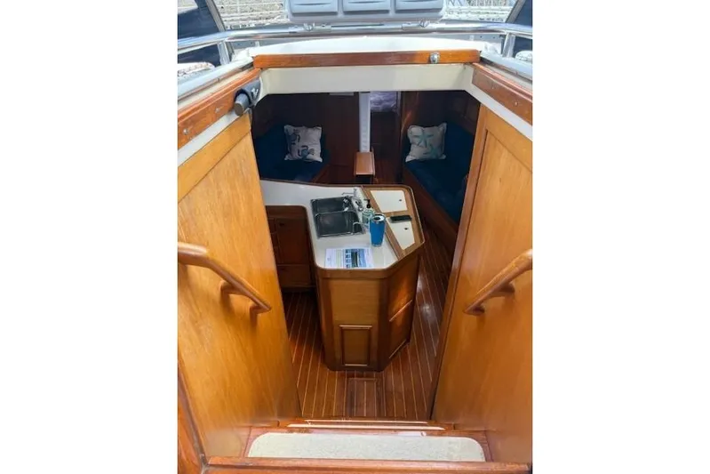 Star Yacht Photos Pics Interior view of 1998 Sabre 402 sailboat with wooden cabinetry and compact kitchen area.