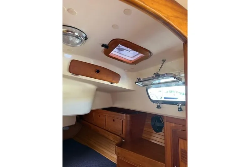 Star Yacht Photos Pics Interior of 1998 Sabre 402 sailboat with wooden cabinetry and porthole window.