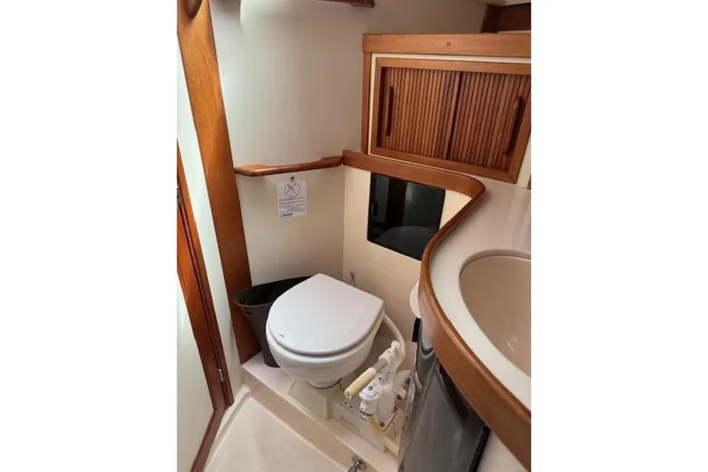Star Yacht Photos Pics 1998 Sabre 402 yacht bathroom with wooden cabinetry and compact toilet.