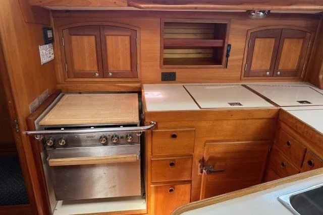 Star Yacht Photos Pics 1998 Sabre 402 yacht kitchen with wooden cabinetry and stainless steel stove.