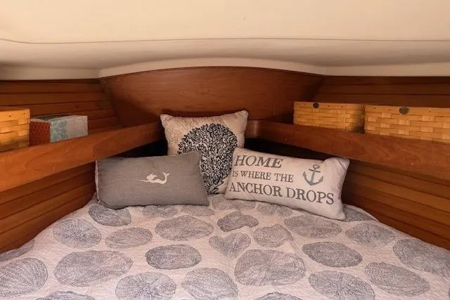 Star Yacht Photos Pics Cozy cabin interior of 1998 Sabre 402 sailboat with decorative pillows and wooden shelves.