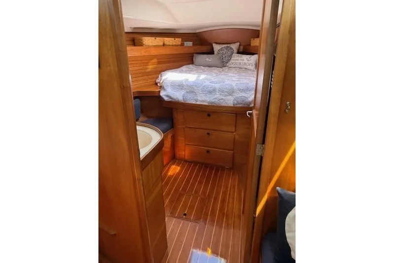 Star Yacht Photos Pics Cozy cabin interior of 1998 Sabre 402 sailboat with wooden finish and bed.
