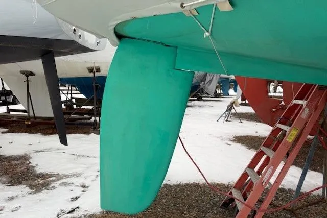 Star Yacht Photos Pics Sabre 402 sailboat rudder, 1998 model, in a snowy boatyard with ladder nearby.