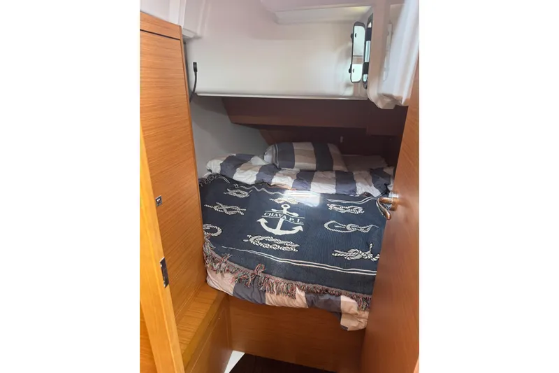 Squeeze De Citron Yacht Photos Pics Cozy cabin interior of 2023 Dufour 37 yacht with nautical-themed bedding.