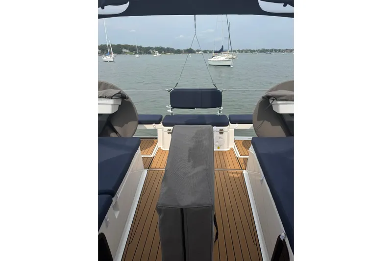 Squeeze De Citron Yacht Photos Pics 2023 Dufour 37 yacht deck with seating, overlooking calm waters and distant sailboats.