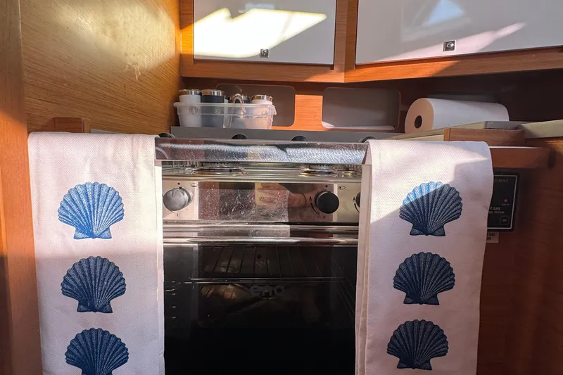 Squeeze De Citron Yacht Photos Pics Cozy kitchen in 2023 Dufour 37 yacht with seashell-themed towels and modern appliances.