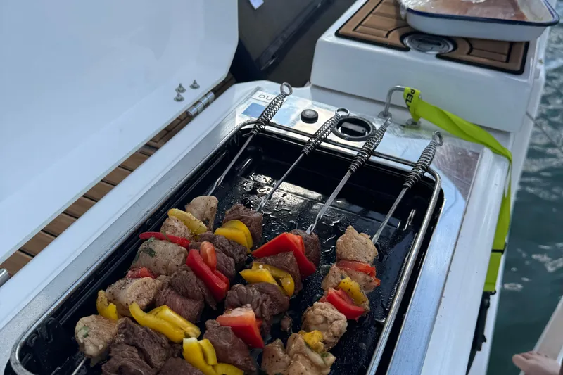 Squeeze De Citron Yacht Photos Pics Grilling skewers on a Dufour 37 yacht, 2023 model, with vibrant vegetables and meat.