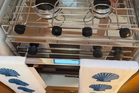 Squeeze De Citron Yacht Photos Pics 2023 Dufour 37 yacht kitchen with stove and decorative towels.
