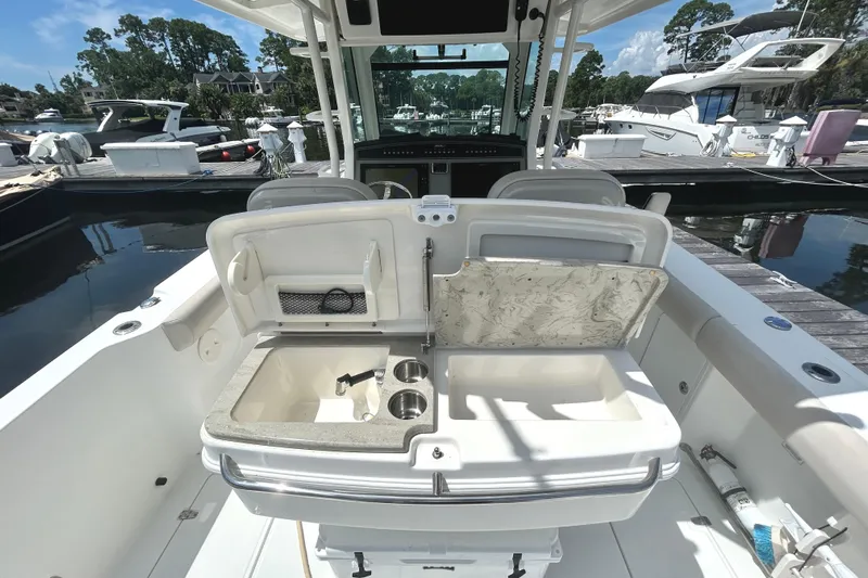  Yacht Photos Pics 2017 Boston Whaler 330 Outrage boat interior with open storage and seating at marina.
