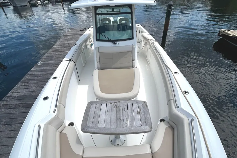  Yacht Photos Pics 2017 Boston Whaler 330 Outrage boat docked, featuring spacious seating and a wooden table.