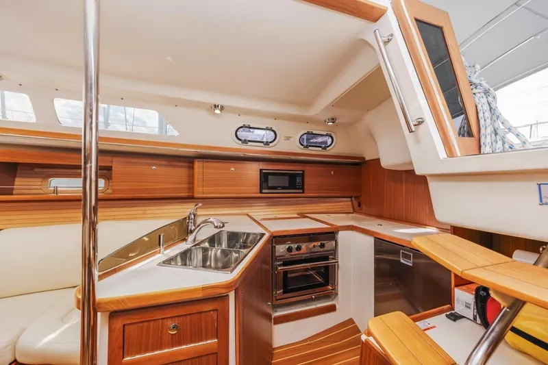 Nina Mia Yacht Photos Pics Interior of 2018 Catalina 385 sailboat kitchen with wood finish and modern appliances.