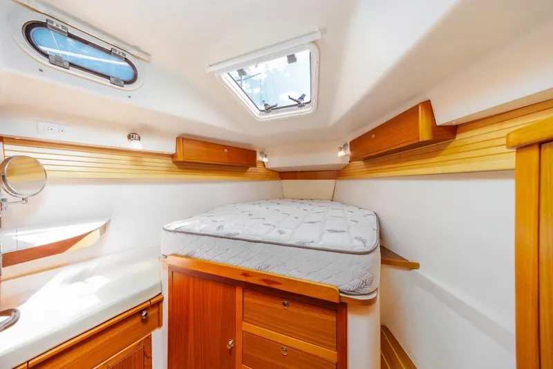 Nina Mia Yacht Photos Pics 2018 Catalina 385 yacht interior cabin with bed, wooden cabinets, and skylight.
