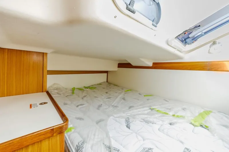 Nina Mia Yacht Photos Pics Cozy cabin interior of 2018 Catalina 385 sailboat with wooden accents and bedding.