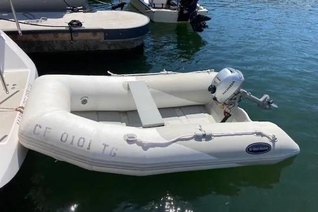 Nina Mia Yacht Photos Pics White inflatable boat with outboard motor docked on water, Catalina 385, 2018 model.