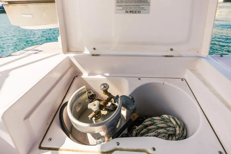 Nina Mia Yacht Photos Pics Catalina 385 (2018) yacht propane storage compartment with coiled rope and gas regulator.