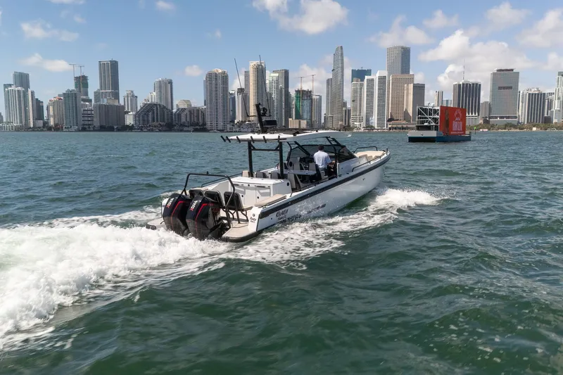 Kraken Yacht Photos Pics Axopar SHADOW 900ST 2023 on water with city skyline backdrop.
