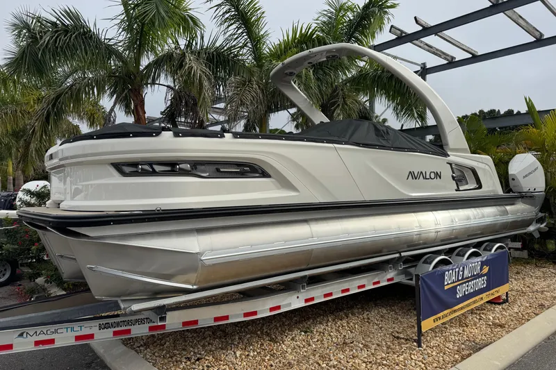  Yacht Photos Pics 2026 Avalon Excalibur 27' boat on trailer, surrounded by palm trees.
