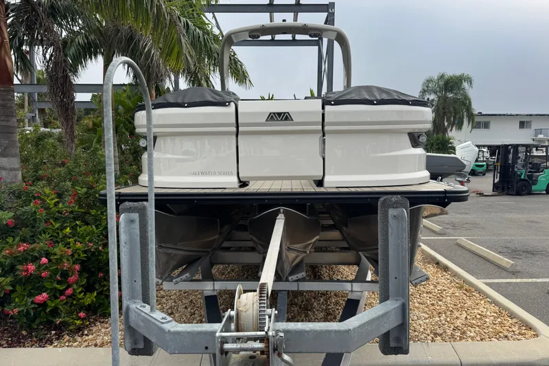  Yacht Photos Pics 2026 Avalon Excalibur 27' boat on trailer, surrounded by tropical plants.