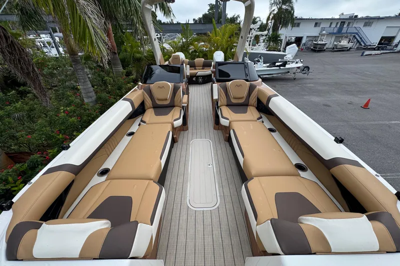  Yacht Photos Pics 2026 Avalon Excalibur 27' boat interior with tan and brown seating, docked near palm trees.