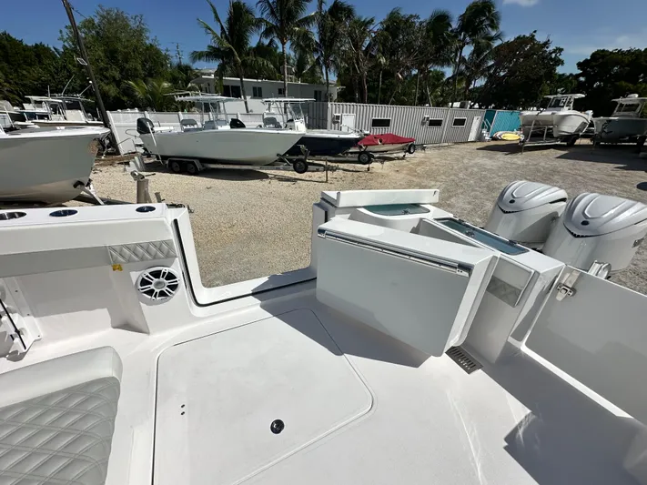  Yacht Photos Pics 2026 Twin Vee 400 GFX2 CC boat interior with open storage, docked among other boats.