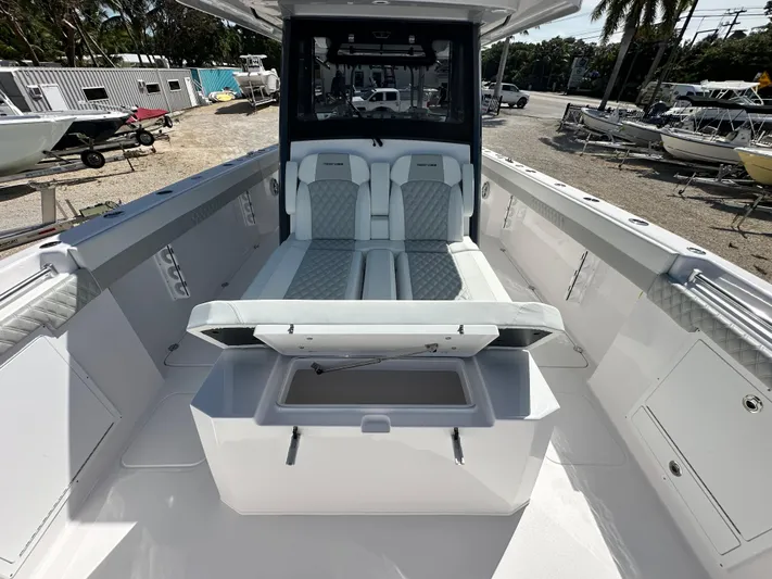  Yacht Photos Pics 2026 Twin Vee 400 GFX2 CC boat interior with seating and storage, docked outdoors.