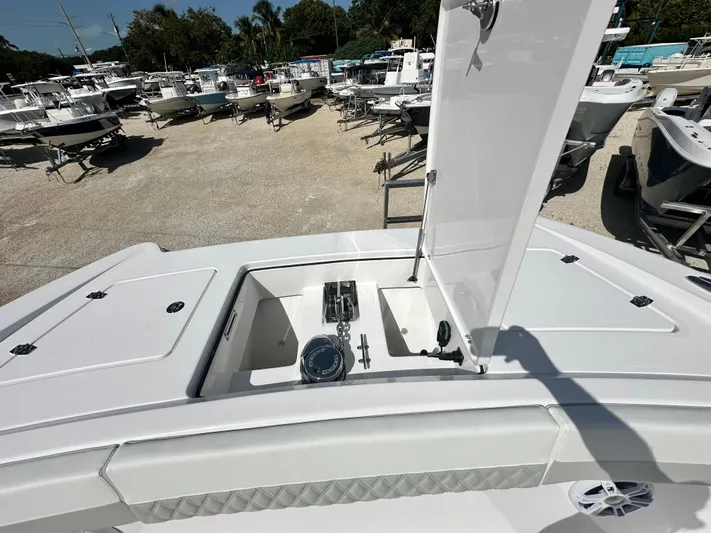  Yacht Photos Pics 2026 Twin Vee 400 GFX2 CC boat with open storage compartment, surrounded by other boats.