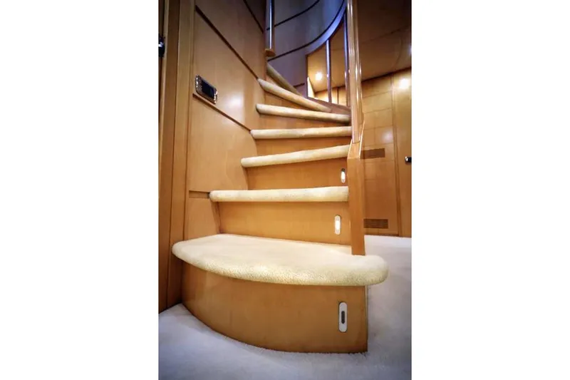  Yacht Photos Pics Curved wooden staircase inside 1998 Maiora MAIORA 29 DP yacht, featuring carpeted steps.