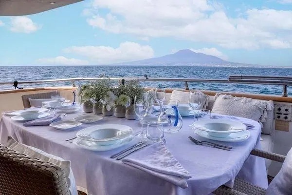  Yacht Photos Pics Elegant dining setup on Maiora 29 DP yacht, 1998, with ocean and mountain view.