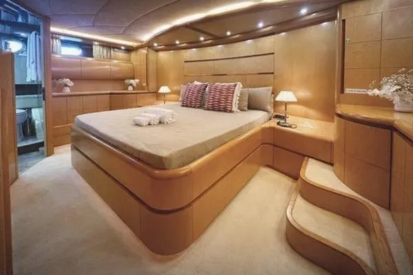  Yacht Photos Pics Luxurious bedroom interior of 1998 Maiora MAIORA 29 DP yacht with elegant wood paneling.