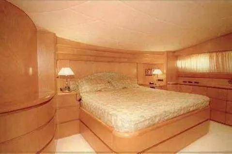  Yacht Photos Pics Luxurious bedroom interior of 1998 Maiora MAIORA 29 DP yacht with elegant wood finish.