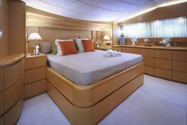  Yacht Photos Pics Luxurious bedroom interior of 1998 Maiora MAIORA 29 DP yacht with elegant wood furnishings.