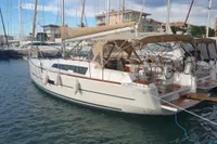 2015 Dufour 382 Grand Large yacht docked in marina, surrounded by other boats.