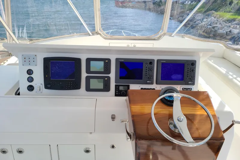 Black Gold Yacht Photos Pics Helm of 2006 Egg Harbor 50 Sport Yacht with navigation instruments and steering wheel.