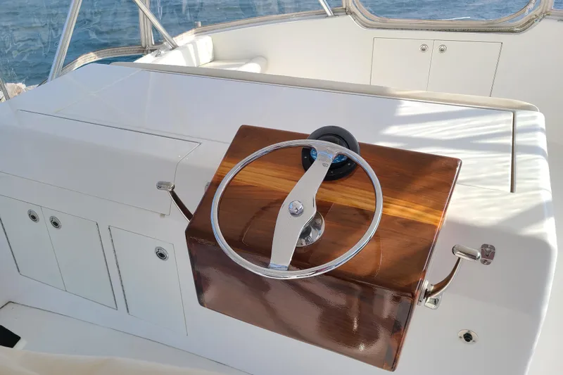 Black Gold Yacht Photos Pics Steering wheel of a 2006 Egg Harbor 50 Sport Yacht, featuring a polished wood finish.