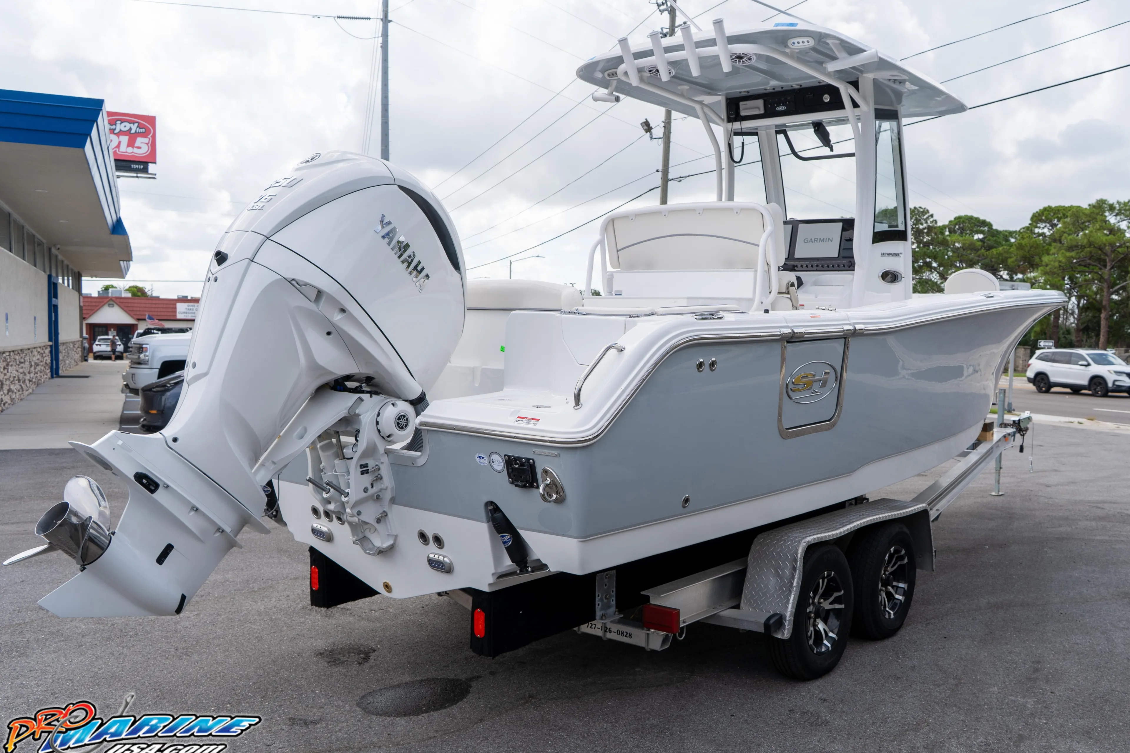 2026 Sea Hunt Ultra 255 SE boat on trailer with Yamaha engine, parked outdoors.
