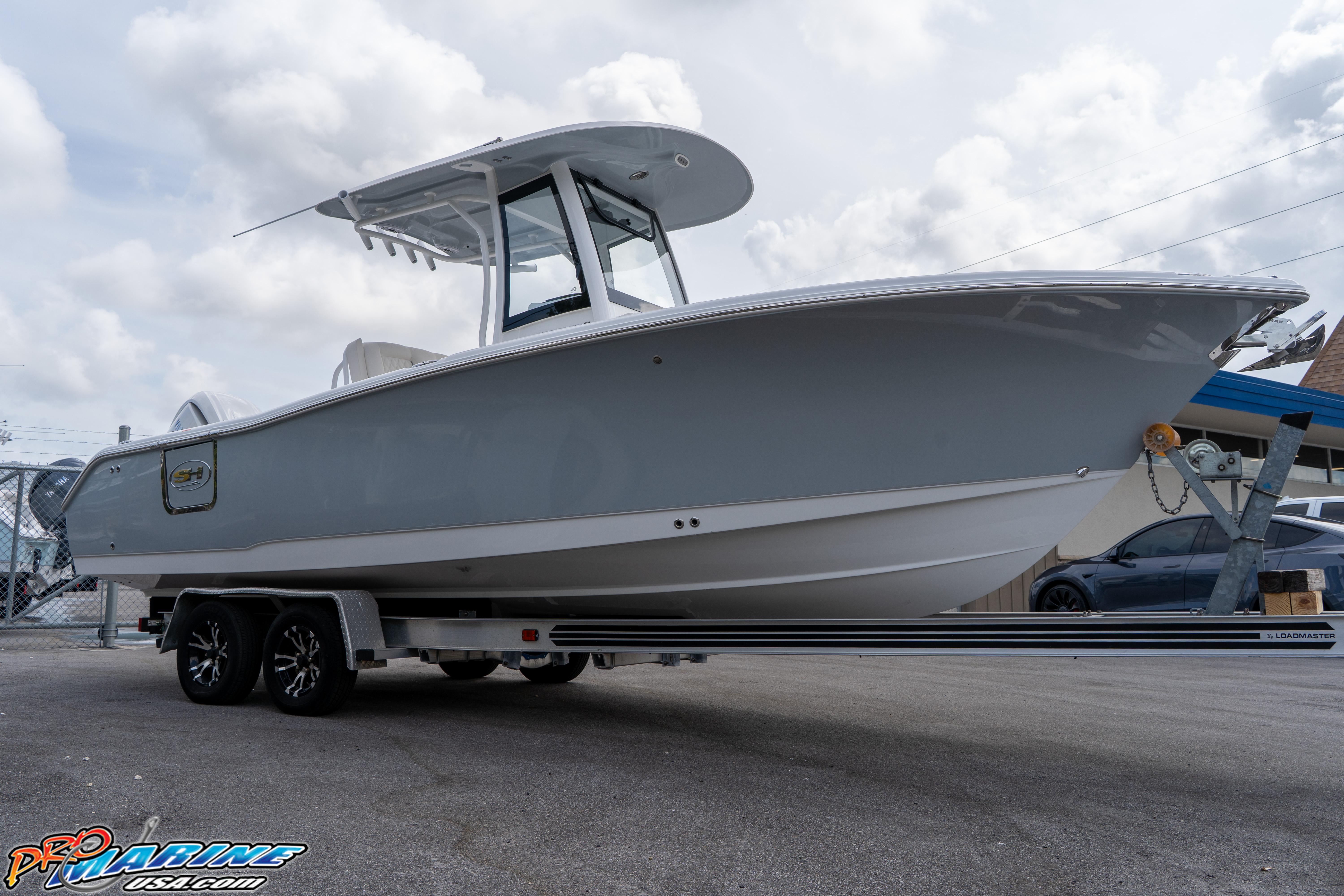 2026 Sea Hunt Ultra 255 SE boat on trailer, displayed outdoors under cloudy sky.