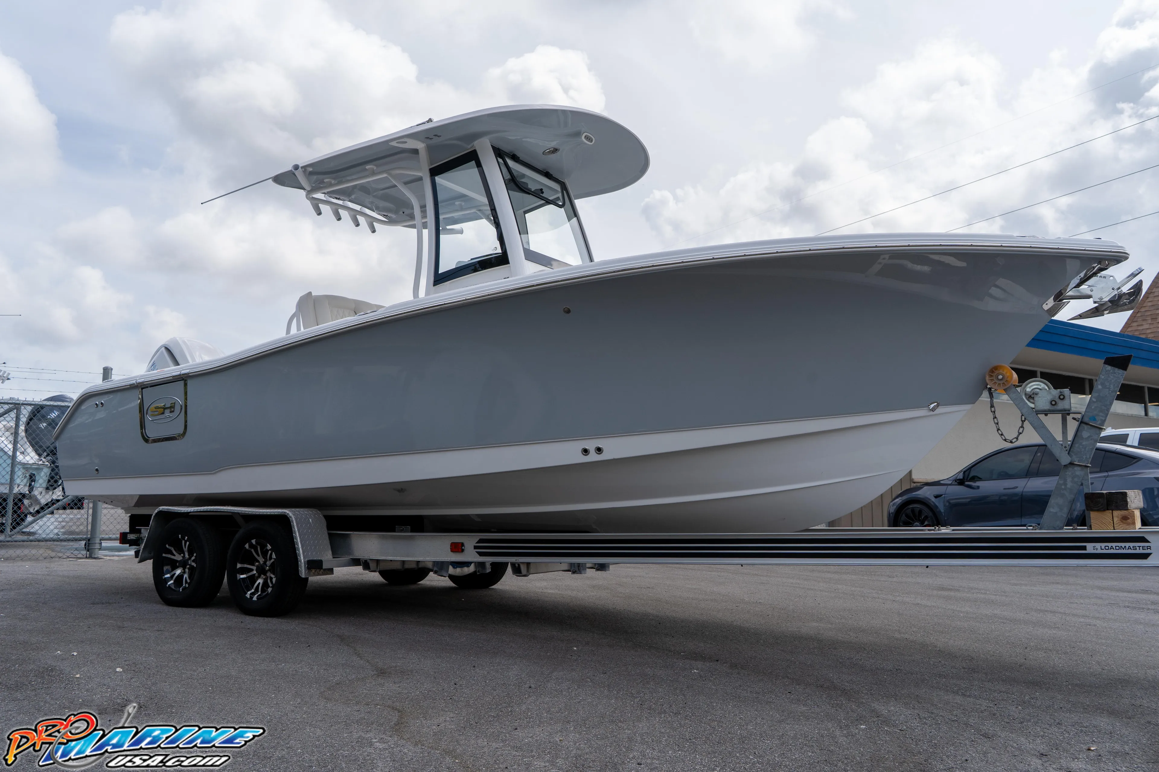 2026 Sea Hunt Ultra 255 SE boat on trailer, displayed outdoors under cloudy sky.
