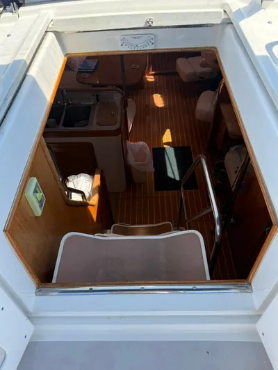  Yacht Photos Pics Interior view of 2005 Catalina 470 sailboat, showcasing wooden flooring and compact kitchen area.