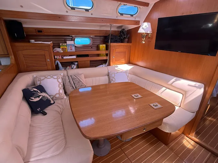  Yacht Photos Pics Cozy interior of 2005 Catalina 470 yacht with wooden table and plush seating.
