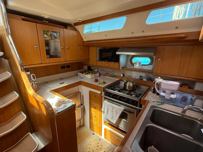  Yacht Photos Pics 2005 Catalina 470 yacht interior kitchen with wooden cabinets and modern appliances.