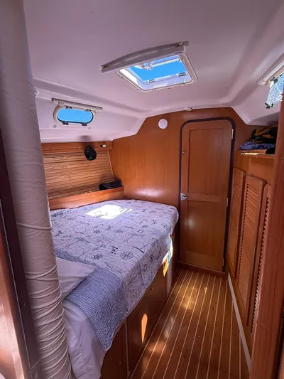 Yacht Photos Pics Interior cabin of a 2005 Catalina 470 sailboat with cozy bed and wooden finish.
