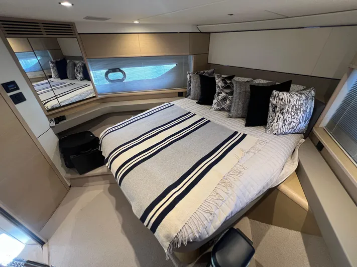 Balance Yacht Photos Pics Luxurious bedroom interior of 2018 Princess F55 yacht with striped bedding and decorative pillows.