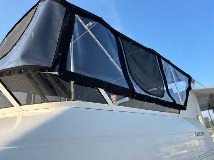 Musketeer Yacht Photos Pics 2000 Carver 406 Aft Cabin Motor Yacht with black canopy against blue sky.